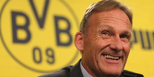 BVB-Chef Hans-Joachim Watzke vor Vereinslogo