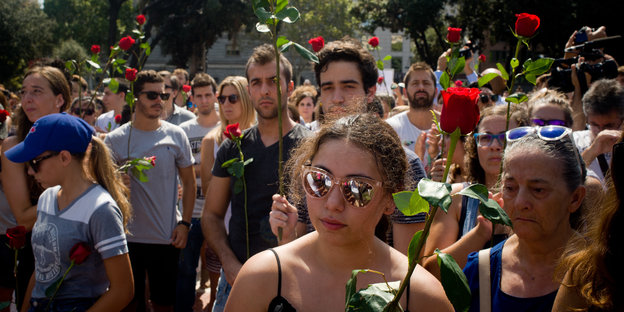 Menschen in Barcelona zeigen rote Rosen