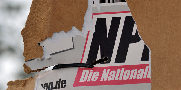 Ein zur Hälfte abgerissenes NPD-Plakat
