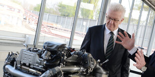 Winfried Kretschmann betrachtet einen Dieselmotor