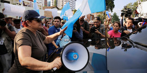 Eine Menschenmenge, viele haben blau-weiße Flaggen