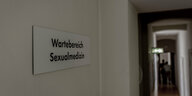 ein Gang, an der Wand ein Schild mit der Aufschrift „Wartebereich Sexualmedizin“