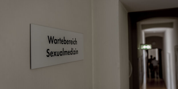 ein Gang, an der Wand ein Schild mit der Aufschrift „Wartebereich Sexualmedizin“ ein Gang, an der Wand ein Schild mit der Aufschrift „Wartebereich Sexualmedizin“