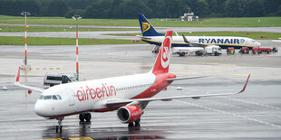 Ein Flugzeug der Air Berlin steht auf dem Rollfeld, dahinter ein Flugzeug der Fluglinie Ryanair