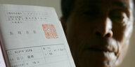 Alter Mann zeigt einen Ausweis