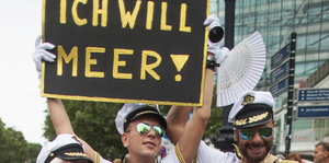 Als Seeleute verkleidete Männer bei einer Parade zum Christopher Street Day, sie halten ein Schild, auf dem steht: Ich will Meer!