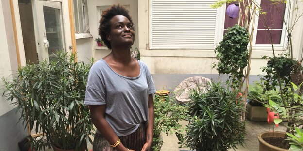 Die französische Schriftstellerin Aya Cissoko steht in einem Innenhof in Paris