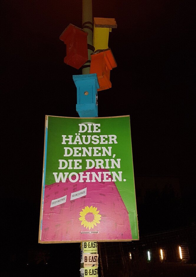 Ein Wahlplakat, auf dem steht: „Die Häuser denen, die drin wohnen“