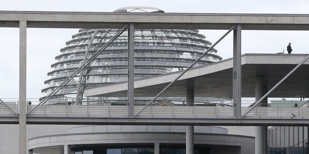 Scheiben und Gestänge eines Hauses, dahinter die Bundestagskuppel