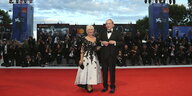 Im Vordergrund sind die Schauspieler Helen Mirren und Donald Sutherland auf dem roten Teppich zu sehen, im Hintergrund die Fotografen