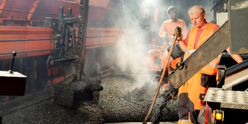 Bauarbeiter vor dampfendem Asphalt