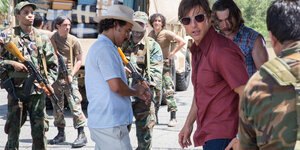 Tom Cruise zwischen uniformierten und bewaffneten Gestalten