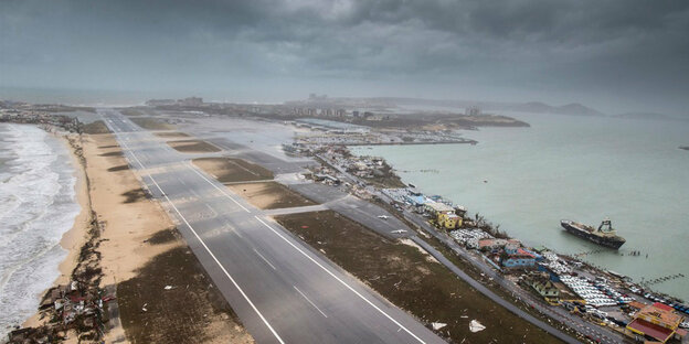 Eine Straße trennt zwei Küsten auf der Antilleninsel Sint Maarten, die Wolken darüber deuten stürmisches Wetter an