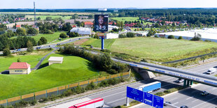 Straßen, Autos, Landschaft und ein Merkel-Plakat