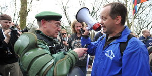 Monty Schädel mit Megafon diskutiert mit dem Einsatzleiter einer Demonstration