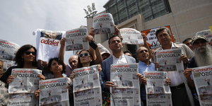 Journalisten und Aktivisten halten vor dem Gericht in Istanbul Ausgaben der "Cumhuriyet" hoch