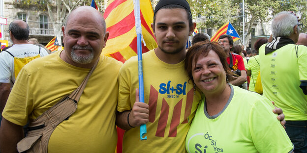 drei Menschen, einer mit der Unabhängigkeitsflagge drei Menschen, einer mit der Unabhängigkeitsflagge