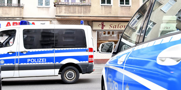 Polizeiwagen stehen vor einem Friseursalon