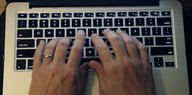 Zwei Hände tippen auf einer Laptoptastatur