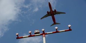 Ein Flugzeug überfliegt einen Signalmasten