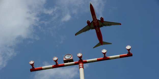 Ein Flugzeug überfliegt einen Signalmasten