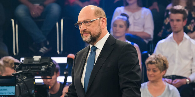 Martin Schulz steht in einem Fernsehstudio und guckt ernst