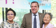 Gerhard Schröder zwischen zwei südkoreanischen Frauen