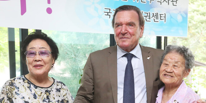 Gerhard Schröder zwischen zwei südkoreanischen Frauen