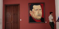 Ein Mitglied der Nationalgarde läuft an einem Gemälde von Hugo Chávez in Caracas vorbei