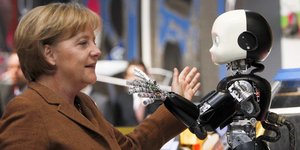 Angela Merkel und ein kinderähnlicher Roboter