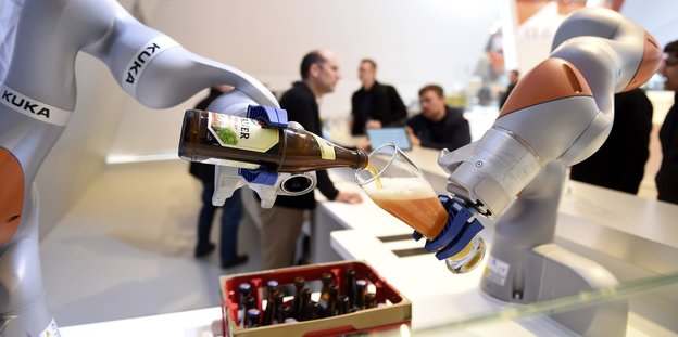 Zwei Roboter in Form von Armen gießen Bier in ein Glas