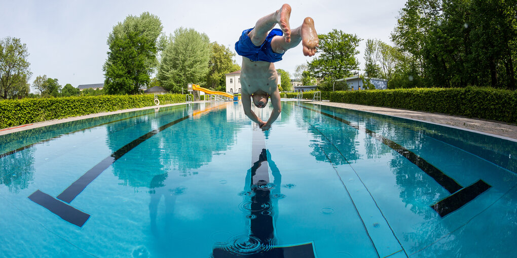 Junge springt ins Schwimmbecken