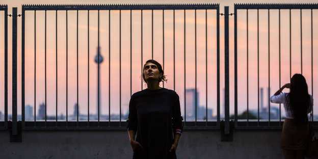 Im Vordergrund Fatma Aydemir, im Hintergrund Berlin bei Sonnenuntergang Im Vordergrund Fatma Aydemir, im Hintergrund Berlin bei Sonnenuntergang
