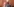 Ein alter Mann mit Halbglatze von der Seite steht vor einem orange-braunem Haus