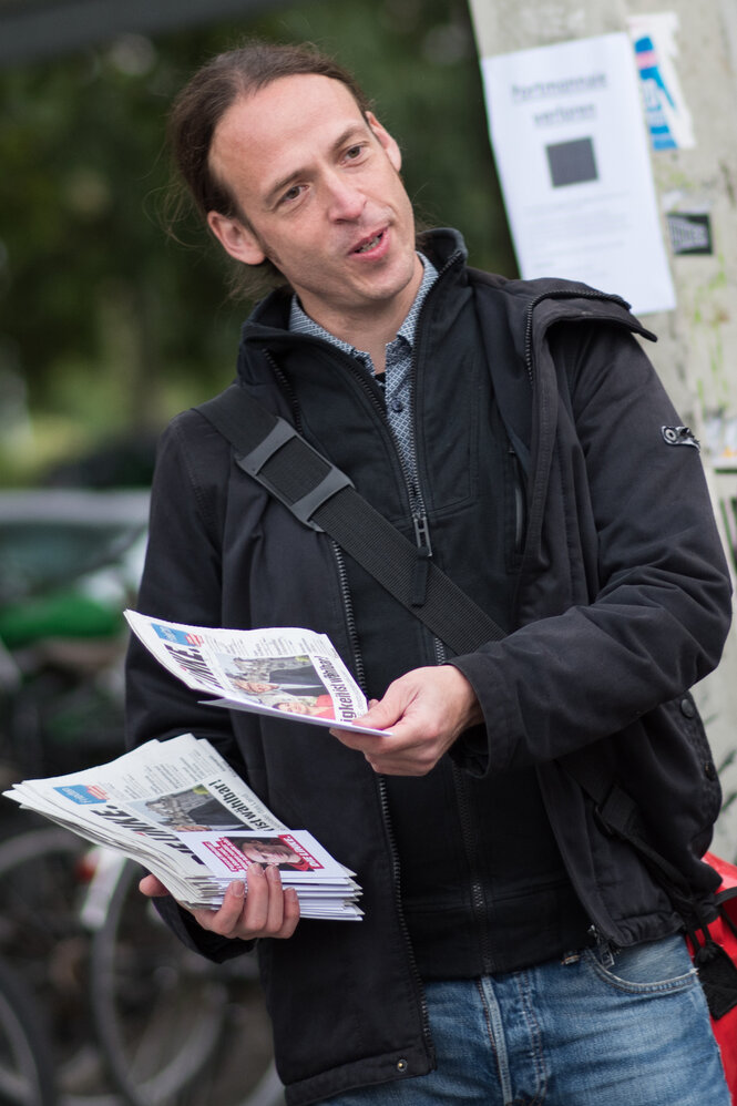 Pascal Meiser verteilt eine Publikation der LINKEN