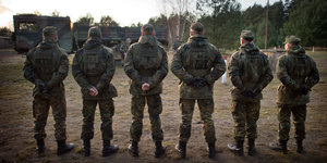 Sechs Männer in Uniform stehen nebeneinander