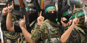 Mitglieder der Izz al-Din al-Qassam-Brigaden, dem militärischen Flügel der Hamas halten ihre Waffen in die Luft