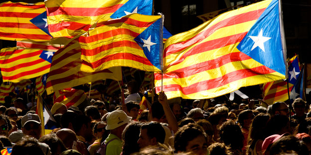 Menschen demonstrieren und halten die Flagge Kataloniens hoch