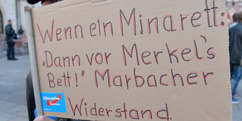 Demonstrant mit Plakat "Wenn ein Minarett, dann vor Merkels Bett"