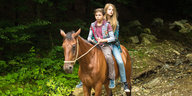 Zwei Kinder auf einem Pferd