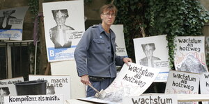 Jan Theiler von der Bergpartei mit Pinsel in der Hand und Plakaten der Bergpartei