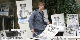 Jan Theiler von der Bergpartei mit Pinsel in der Hand und Plakaten der Bergpartei