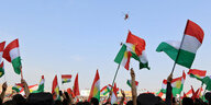 Kurden in der nordirakischen Stadt Duhuk schwenken Fahnen, am Himmel fliegen zwei Helikopter