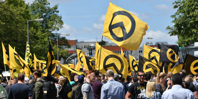 Ein Demozug mit viele Fahnen mit dem Symbol der Identitären Bewegung