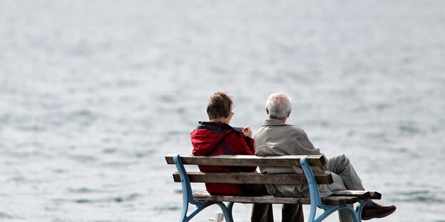 Zwei ältere Menschen auf einer Pank vor einem Gewässer
