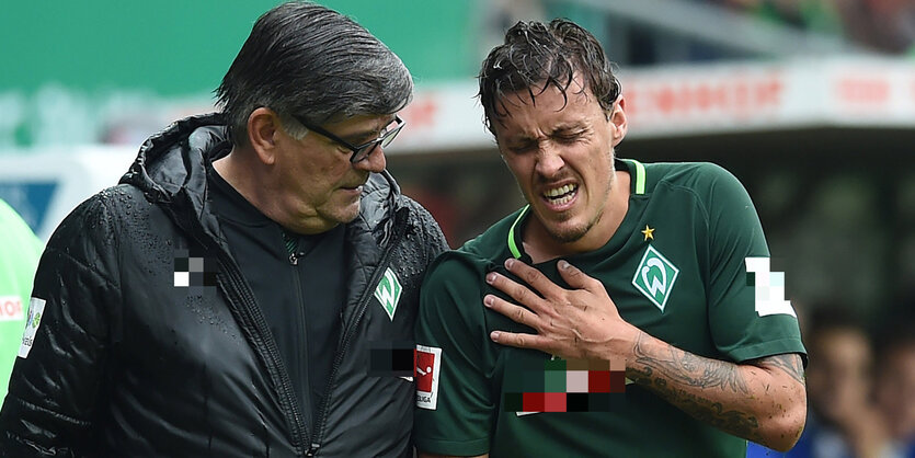 Zwei Männer, einer Arzt, der andere ein verletzter Spieler, Max Kruse