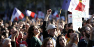 Eine Menschenmenge demonstriert mit Bannern und französischen Flaggen