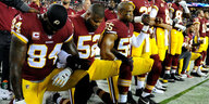 Spieler der Washington Redskins knien nieder vor dem Spiel gegen die Oakland Raiders