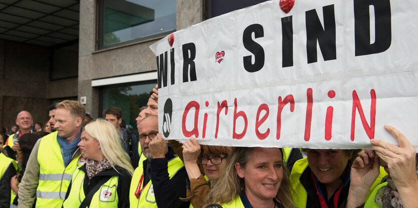 Menschen halten ein Schild hoch, auf dem "Wir sind airberlin" steht