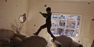 Eine Junge springt in einer Wohnung